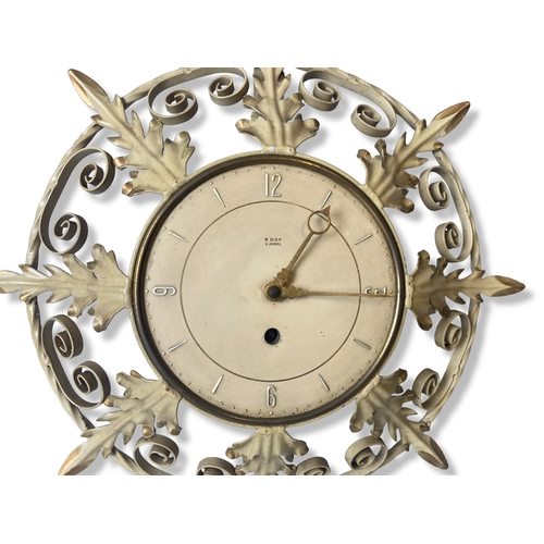 190 - Ornate painted metal 8-day wind up wall clock. Made in great Britain. 
33.5cm Diameter