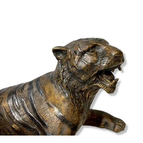 161 - A Bronze sculpture of a recumbent Tiger. 
33 x 15 cm