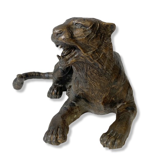 161 - A Bronze sculpture of a recumbent Tiger. 
33 x 15 cm