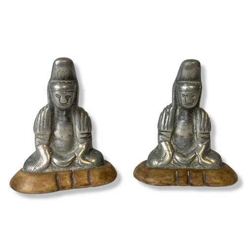 68C - A pair of metal Buddha figures on wooden base. Together with a relief decorated black pottery vase. ... 