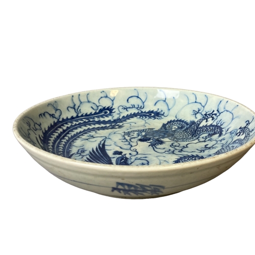 146 - A Chinese porcelain dish. Hand painted with a Dragon and Phoenix. Qing dynasty. 
27.5cm Diameter