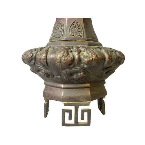 144 - A 19th-century Japanese Bronze vase. Raised on greek-key feet, with relief decorated Dragons & Phoen... 