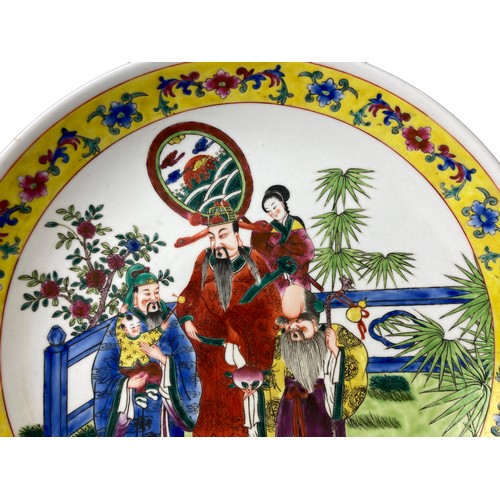 149 - A large hand painted Chinese porcelain charger. Polychrome fenced garden scene, with famille Jaune b... 