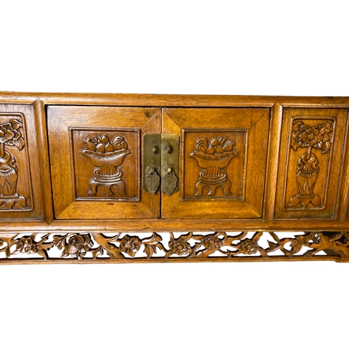 166 - A Chinese carved Elm Meditation / Altar table.
With carved hand-panelled doors and drawers depicting... 