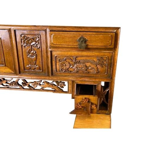 166 - A Chinese carved Elm Meditation / Altar table.
With carved hand-panelled doors and drawers depicting... 