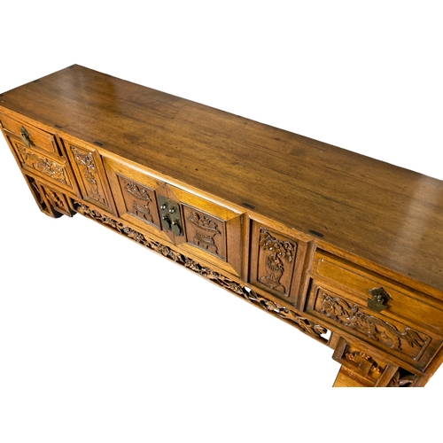 166 - A Chinese carved Elm Meditation / Altar table.
With carved hand-panelled doors and drawers depicting... 