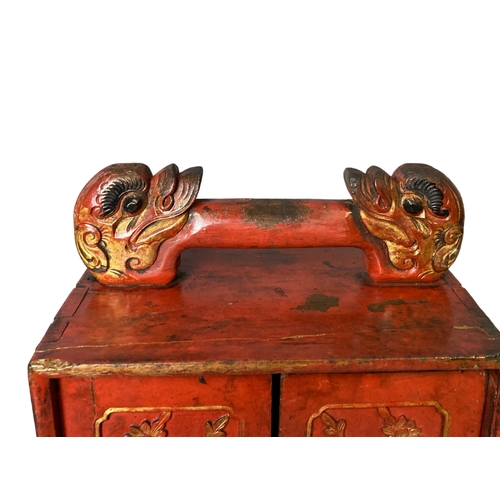 119 - A Qing dynasty Chinese carved red lacquer Scholars cabinet. Carved and gilded Dragon handle and styl... 