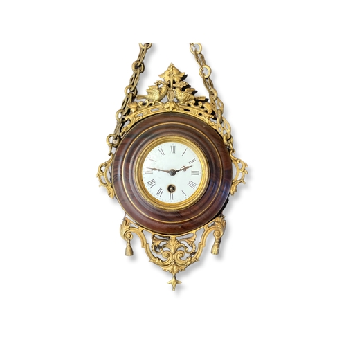 166 - A French Gilt metal hanging wall clock. With faux wood effect surround.  White Enamel face with Roma... 