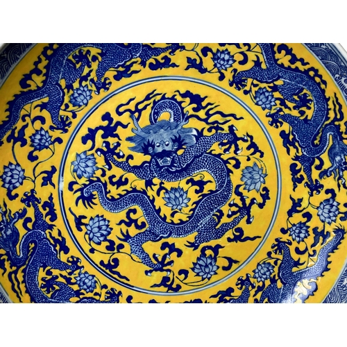 186 - Large Chinese Famille Jaune porcelain charger. Hand painted with a 5-claw Dragon amongst blossoming ... 