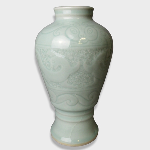 159 - A Chinese porcelain Celadon Vase. Decorated with stylised Dragons above scrolling border.
25cm Tall