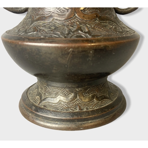 169 - A twin handle Chinese Qing dynasty Bronze vase.
Stylised grape vine handles. 
15cm tall