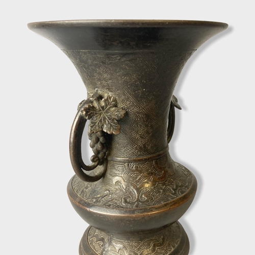 169 - A twin handle Chinese Qing dynasty Bronze vase.
Stylised grape vine handles. 
15cm tall