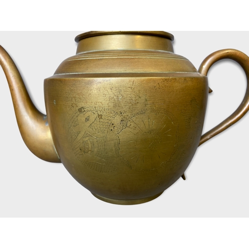 150 - A collection of Chinese teapots. Includes a Yixing relief moulded example, engraved Brass and Cast I... 