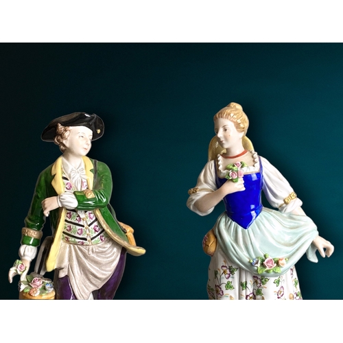 83 - A pair of Sitzendorf hand painted porcelain figures. 
Depicting Flower seller & sweetheart. 
24cm Ta... 