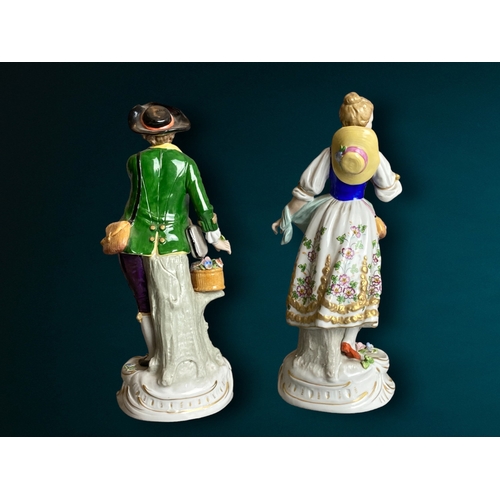 83 - A pair of Sitzendorf hand painted porcelain figures. 
Depicting Flower seller & sweetheart. 
24cm Ta... 