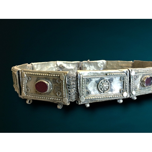 197 - A SOUTH INDIAN METAL & BEJEWLLED BELT.
DECORATED WITH STYLISED AND BEJEWELLED LINKS. 
73CM LONG.