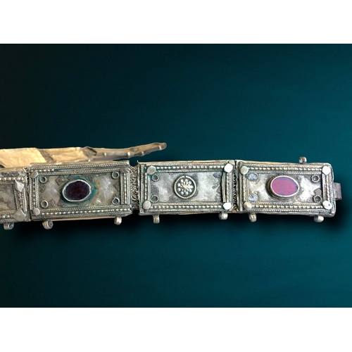 197 - A SOUTH INDIAN METAL & BEJEWLLED BELT.
DECORATED WITH STYLISED AND BEJEWELLED LINKS. 
73CM LONG.