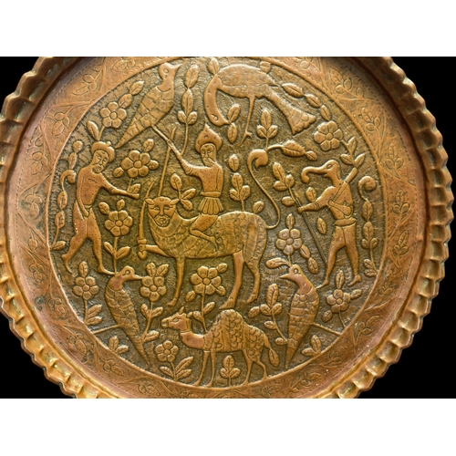 64 - A QAJAR PERSIAN EMBOSSED BRASS WALL PLAQUE.
DEPICTING PERSIAN WARRIOR RIDER ON MYTHICAL ANIMAL, SURR... 