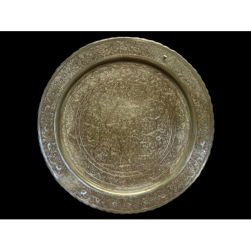 67 - AN ENGRAVED PERSIAN QAJAR SILVER-TONE TRAY.
DEPICTING PERCHING BIRDS AMONGST STYLISED FLORA. 
39CM D... 