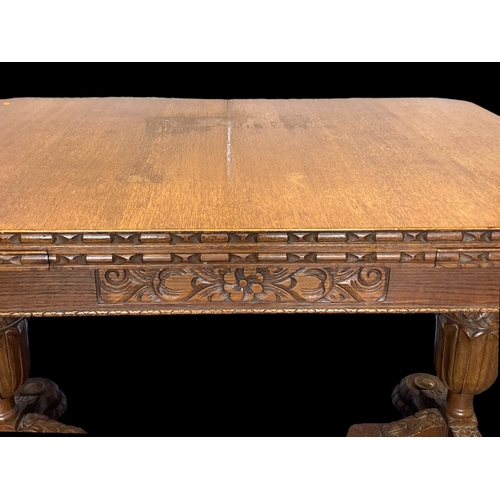 19 - A VICTORIAN CARVED OAK EXTENDING DINING TABLE.