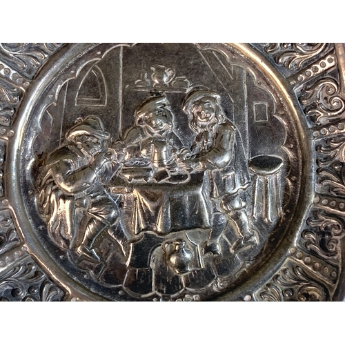 27 - A DUTCH SILVER REPOUSSE DECORATED PIN TRAY.
DEPICTING A PUB SCENE WITH STYLISED BORDER PATTERN. 
12C... 