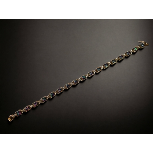 48 - A LADIES 9CT GOLD & MYSTIC TOPAZ LINE BRACELET. 
21CM LONG