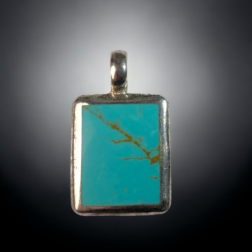 51 - A 925 SILVER & POLISHED TURQUOISE PENDANT.  
40 X 22MM