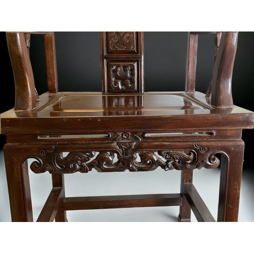 26 - A CHINESE CARVED HARDWOOD ARMCHAIR, 20TH CENTURY. The splat carved with a figure and pierced apron. ... 