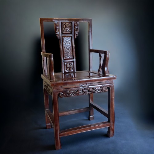 26 - A CHINESE CARVED HARDWOOD ARMCHAIR, 20TH CENTURY. The splat carved with a figure and pierced apron. ... 