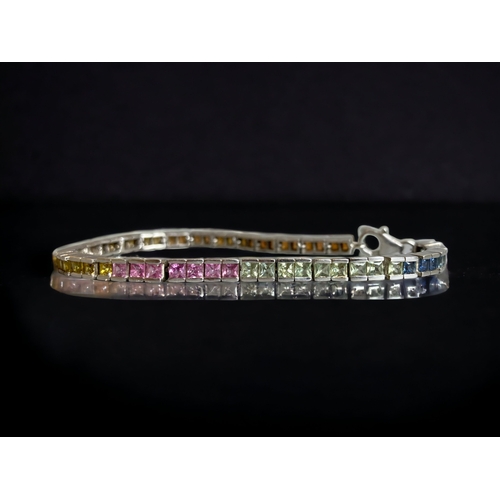 110 - A STERLING SILVER & RAINBOW SAPPHIRE LADIES TENNIS BRACELET.  
7.5