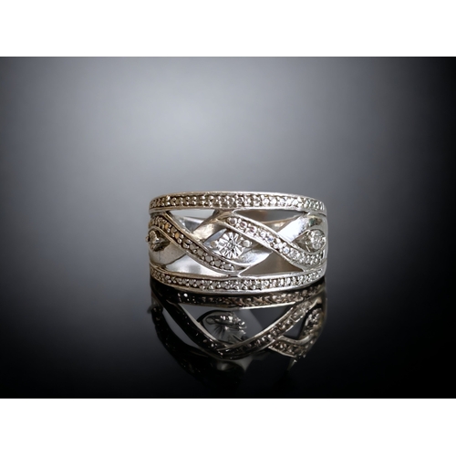 115 - A STERLING SILVER & DIAMOND MARCASITE LADIES RING. SET WITH THREE DIAMONDS IN AN INTERWEAVING DESIGN... 