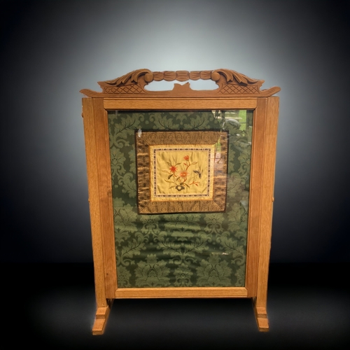 20 - A CARVED OAK FIRE SCREEN FITTED WITH A CHINESE SILK EMBROIDERED PANEL.