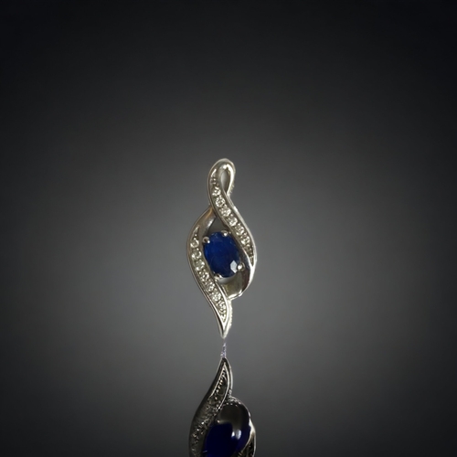 125 - A LADIES 10 CARAT WHITE GOLD, DIAMOND & SAPPHIRE PENDANT. 
22MM LONG.