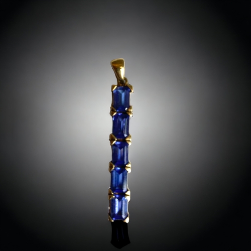 126 - A 9 CARAT GOLD & TANZANITE PENDANT. 
SET WITH FIVE BAGUETTE CUT TANZANITES.
40MM LONG.
2.7G