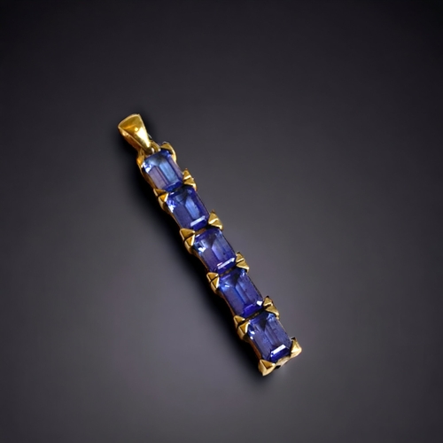 126 - A 9 CARAT GOLD & TANZANITE PENDANT. 
SET WITH FIVE BAGUETTE CUT TANZANITES.
40MM LONG.
2.7G