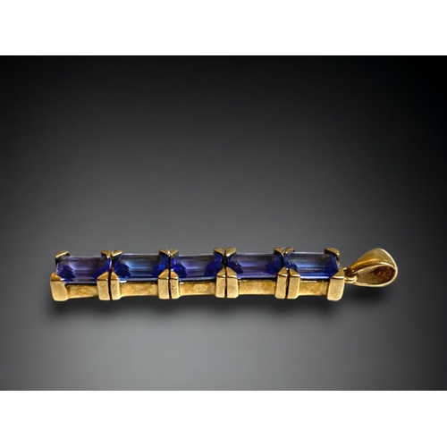 126 - A 9 CARAT GOLD & TANZANITE PENDANT. 
SET WITH FIVE BAGUETTE CUT TANZANITES.
40MM LONG.
2.7G