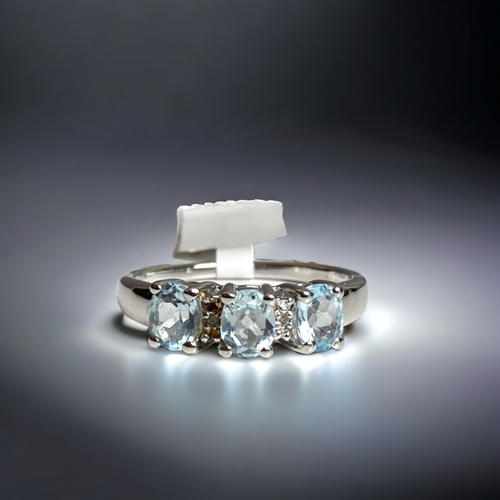 79 - A STERLING SILVER & AQUAMARINE & DIAMOND LADIES DRESS RING. SET WITH THREE AQUAMARINES ACCENTED BY S... 