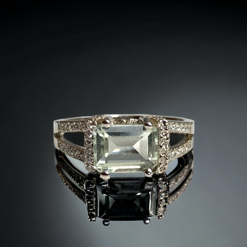 81 - A STERLING SILVER LADIES DRESS RING.SET WITH AN UNKNOWN EMERALD CUT CENTRAL STONE. 
SIZE N 1/2