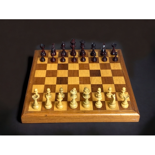 443 - A CARVED WOOD STAUNTON CHESS SET, ON SOLID WOOD BOARD.  WITH BOX.