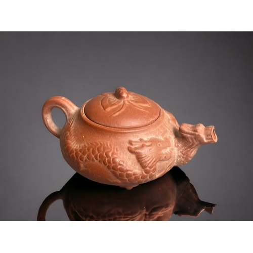 281 - A CHINESE YIXING POTTERY 'DRAGON' MINIATURE TEAPOT. 
4.5 X 11CM