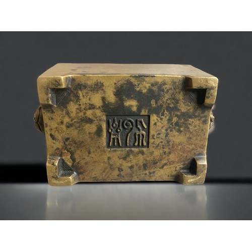 279 - A CHINESE BRONZE INCENSE BURNER.
RECTANGULAR FORM WITH TWIN BUDDHISTIC LION HANDLES. 
MARKS TO BASE.... 