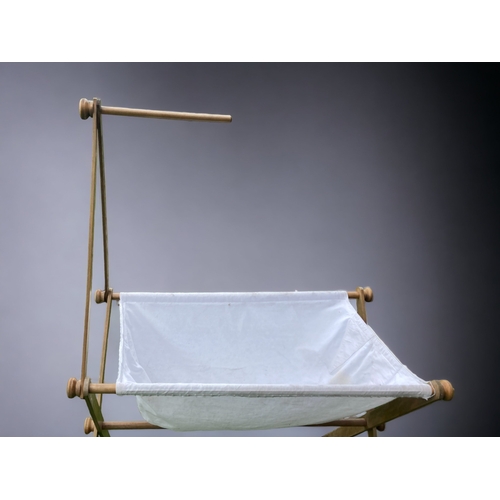 41 - A VINTAGE X FRAME WOOD & LINEN BABY CRIB.