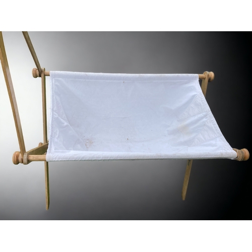 41 - A VINTAGE X FRAME WOOD & LINEN BABY CRIB.