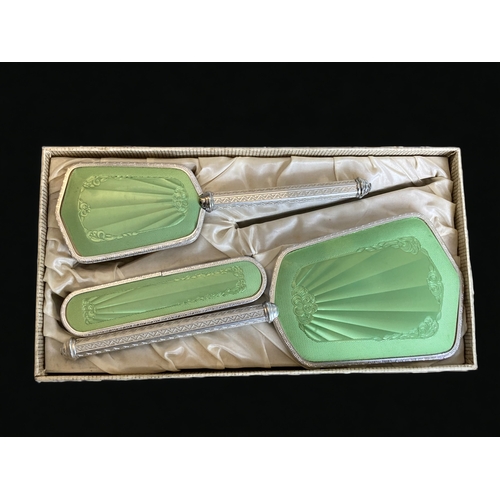 140 - A BOXED 1950's GUILLOCHE STYLE DRESSER BRUSH SET, TOGETHER WITH SIMILAR BRUSH AND CANDLESTICKS.