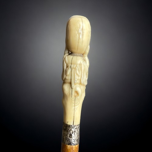 234 - A Japanese Meiji period carved walking stick.
Carved Marine bone figural handle, signed. 
With silve... 