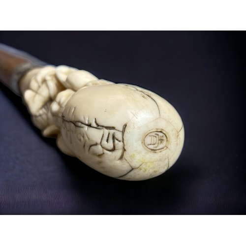 234 - A Japanese Meiji period carved walking stick.
Carved Marine bone figural handle, signed. 
With silve... 