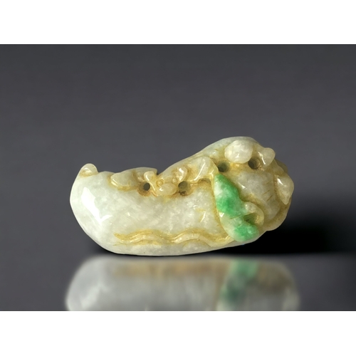 302 - A CHINESE BI COLOUR JADE CARVING. DEPICTING LILY PAD AND A SMALL ANIMAL. 
60MM LONG.