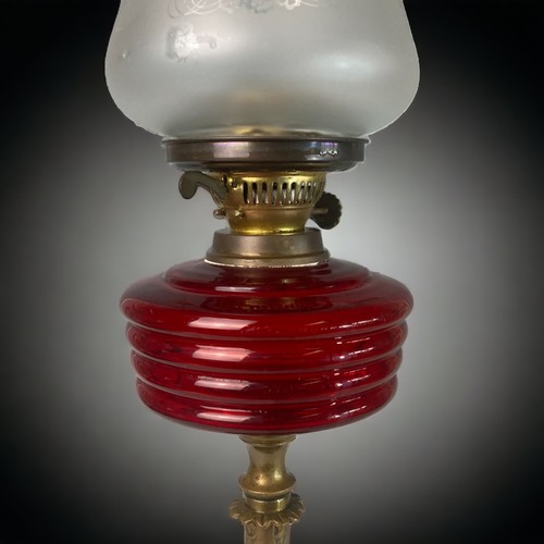 384 - A VICTORIAN RUBY GLASS OIL LAMP. 
CAST BRASS BASE, WITH RUBY WELL AND CRINKLE & ETCHED SHADE. 
52CM ... 