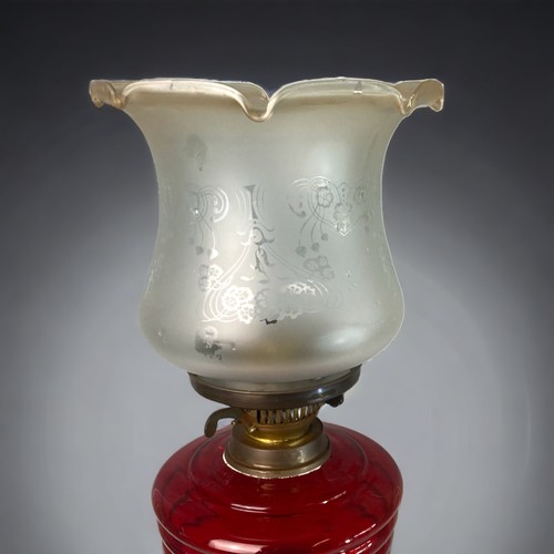 384 - A VICTORIAN RUBY GLASS OIL LAMP. 
CAST BRASS BASE, WITH RUBY WELL AND CRINKLE & ETCHED SHADE. 
52CM ... 