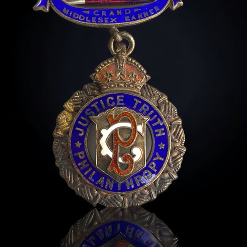 84 - AN HMS 1926 SILVER GILT R.A.O.B  ENAMELLED JEWEL WITH SHIELD ON RIBBON.